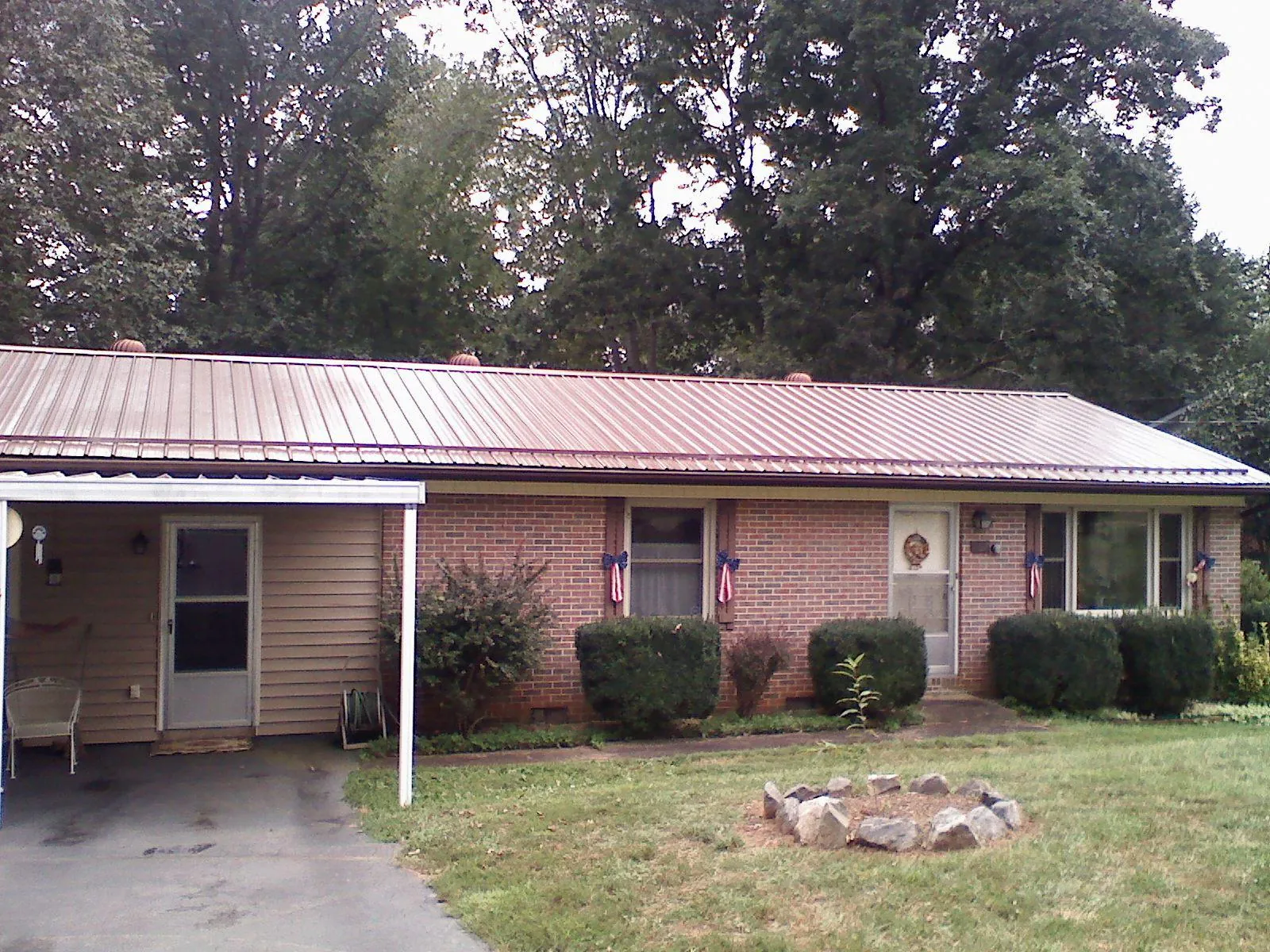Bronze metal roof and carport on a brick ranch home — Roof Repair work by our crew in Hoschton